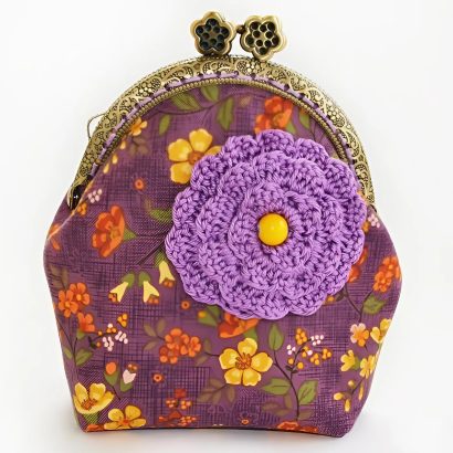 жіноча косметичка - гаманець своїми руками з щільної бавовни у фіолетовій гамі з малюнком - квітами. Косметичка з тканини прикрашена великою в'язаною гачком квіткою. Косметичка з фермуаром є сьогодні найбільш затребуваним аксесуаром! Вірна супутниця сучасної жінки - гаманець косметичка!
