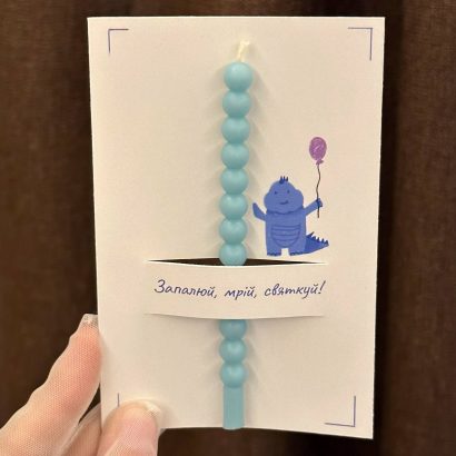 Дитяча листівка з блакитною свічкою, сірником та чиркалом