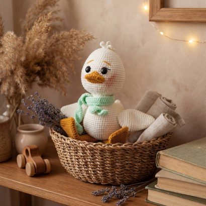 В'язана іграшка біле маленьке каченятко з шаликом