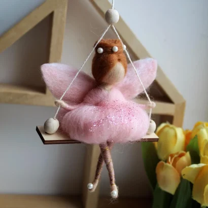 Лялька руда ангел в рожевій сукні на дерев’яній качелі