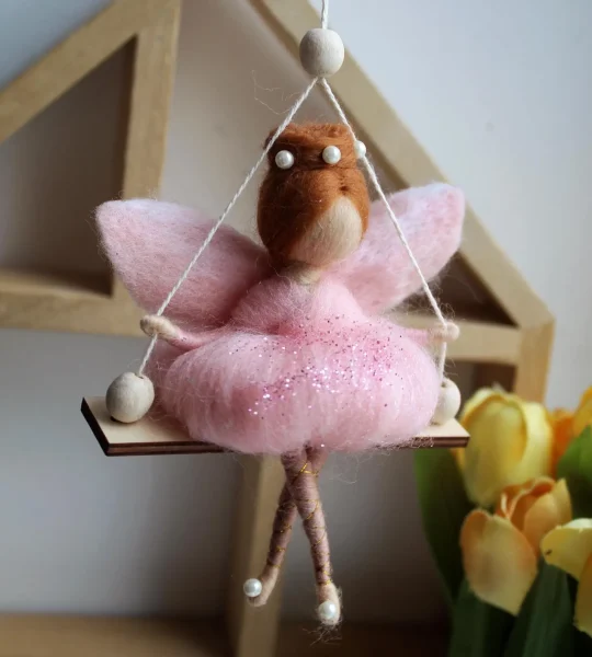 Лялька руда ангел в рожевій сукні на дерев’яній качелі