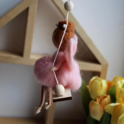 Лялька руда ангел в рожевій сукні на дерев’яній качелі