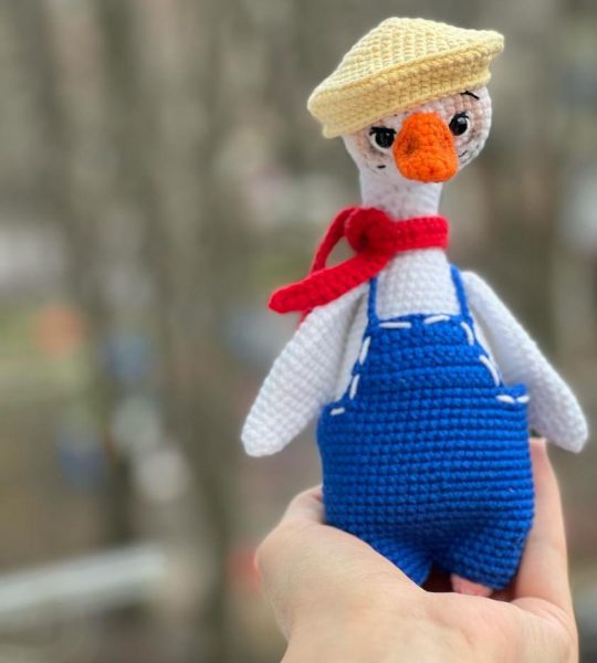 В’язана іграшка біле гусенятко в комбінезоні з кепкою