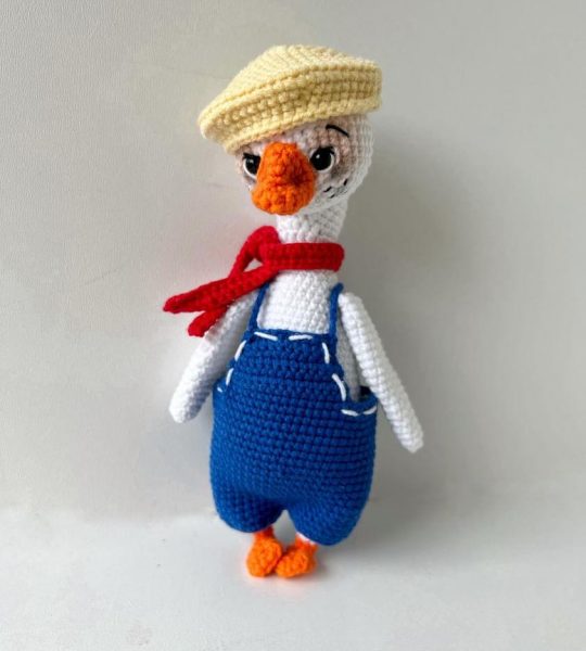 В’язана іграшка біле гусенятко в комбінезоні з шапочкою