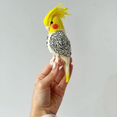 Іграшка в'язаний папуга в жовто-білому кольорі