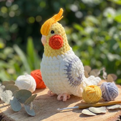 Авторська іграшка в’язаний папуга в жовто-білому кольорі