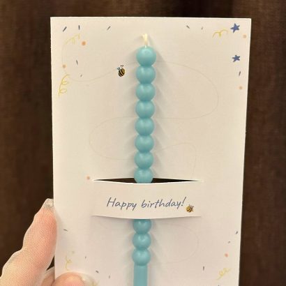 Листівка Happy birthday з блакитною свічкою, сірником та чикалом