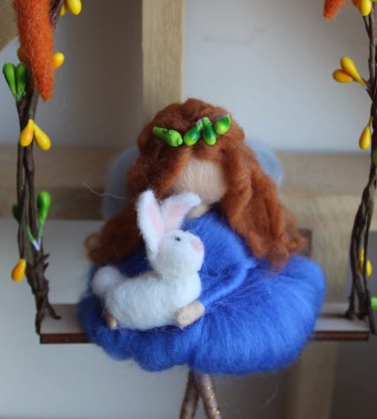 Лялька рудоволося з милим кроликом на гойдалці Великдень