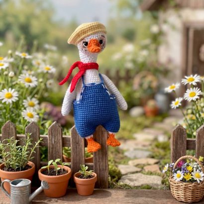 В’язана іграшка біле гусенятко в комбінезоні з кепкою