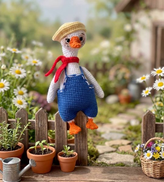 В’язана іграшка біле гусенятко в комбінезоні з кепкою